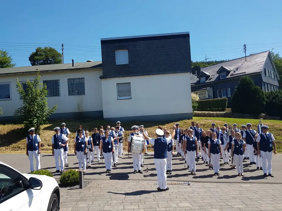 Das Tambourkorps in Aufstellung vor dem Festzug, vorne gibt der Tambourmajor mit erhobenem Arm das Zeichen zum Einsatz